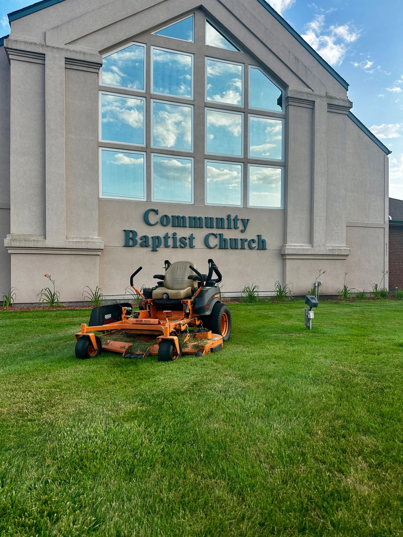 A CV Landscaping mower parked at Community Baptist Church