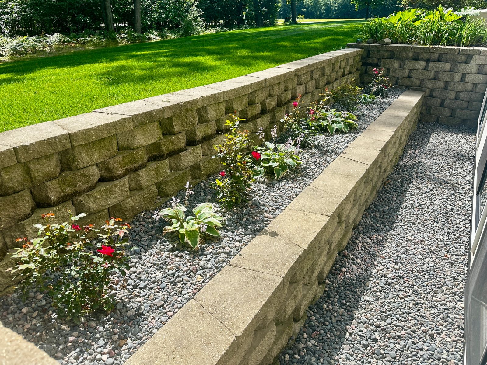 A block retaining wall with new plantings and stone